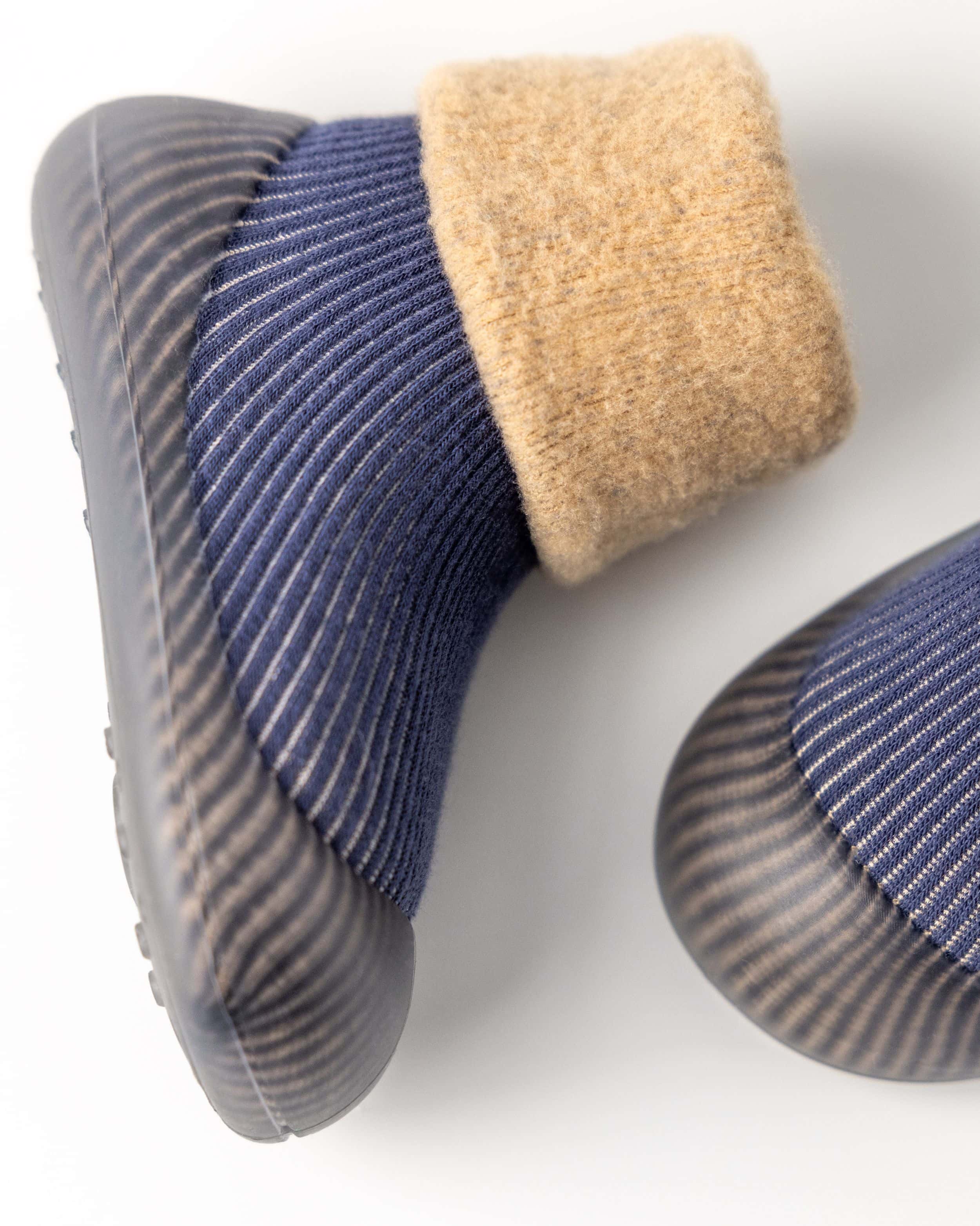 Blå prewalker vintersko til baby med beige fór og skridsikker sål, set fra siden.