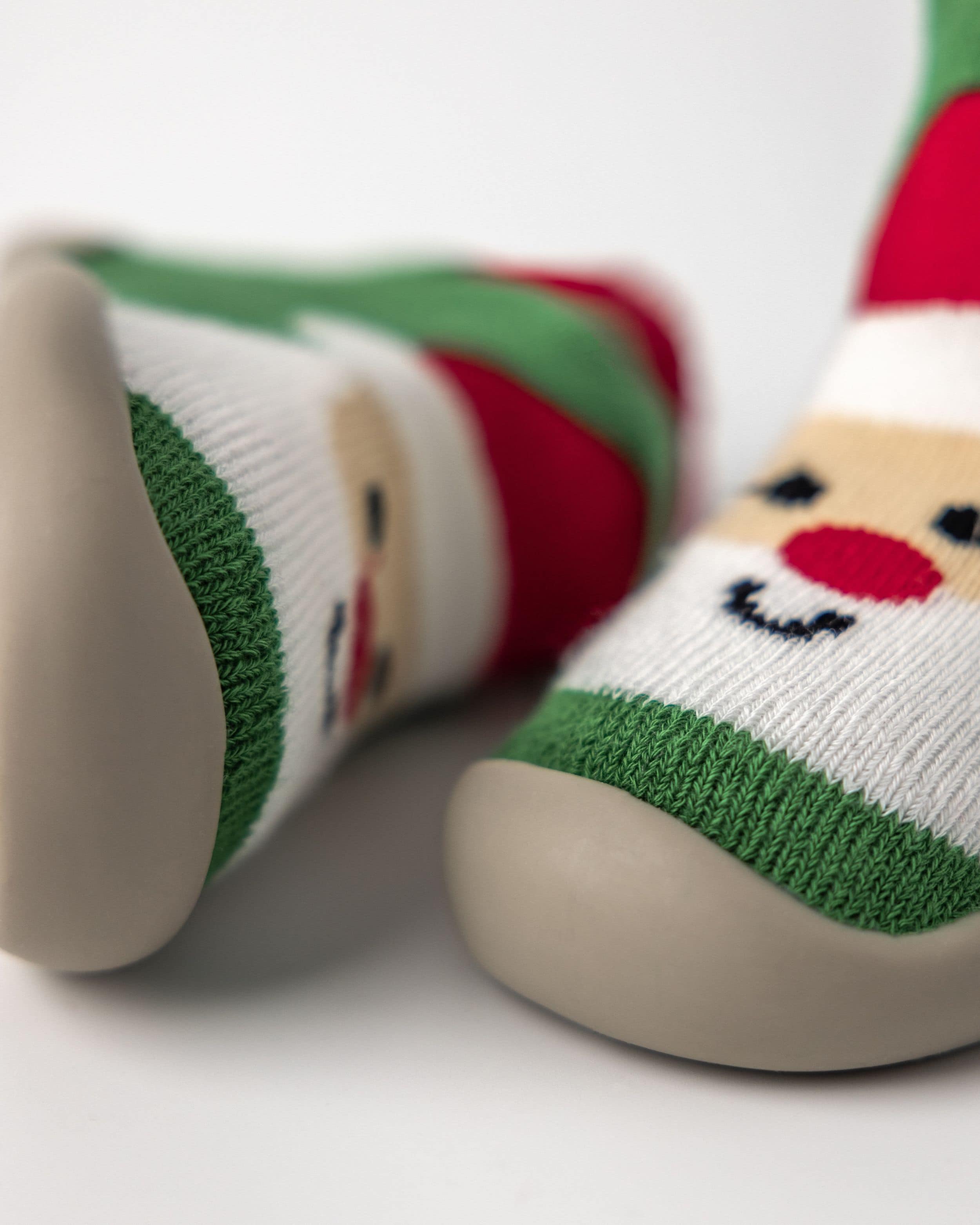 Nærbillede af julesko til børn med julemandmotiv og skridsikker sål, perfekte til vinterbrug