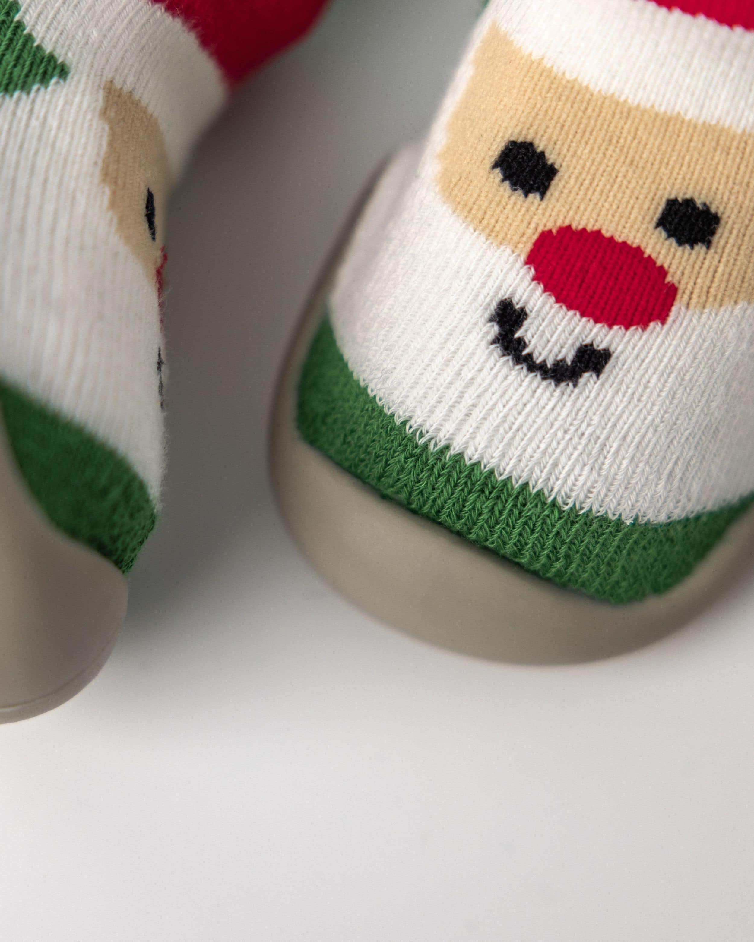 Babysko med julemand-motiv i røde, grønne og hvide farver, perfekte som julesko til små børn