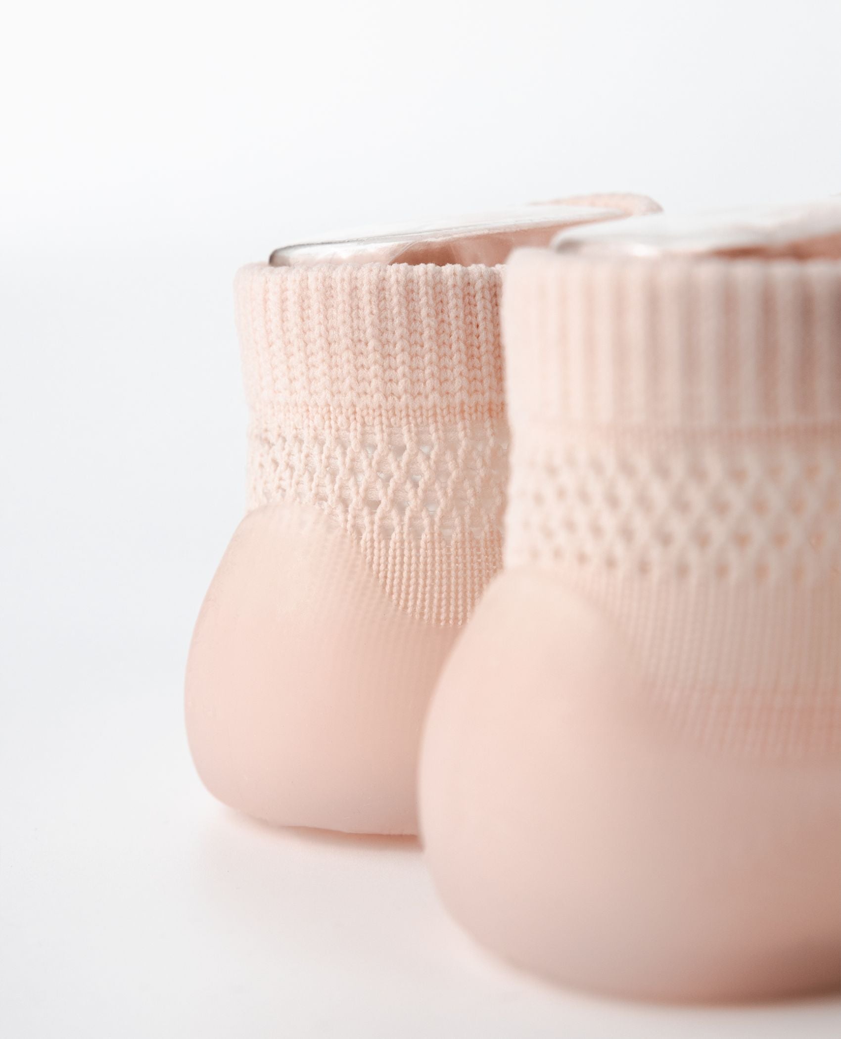 Detaljeret nærbillede af lyserød sommer begyndersko med fleksibel hæl og letvægtssål.