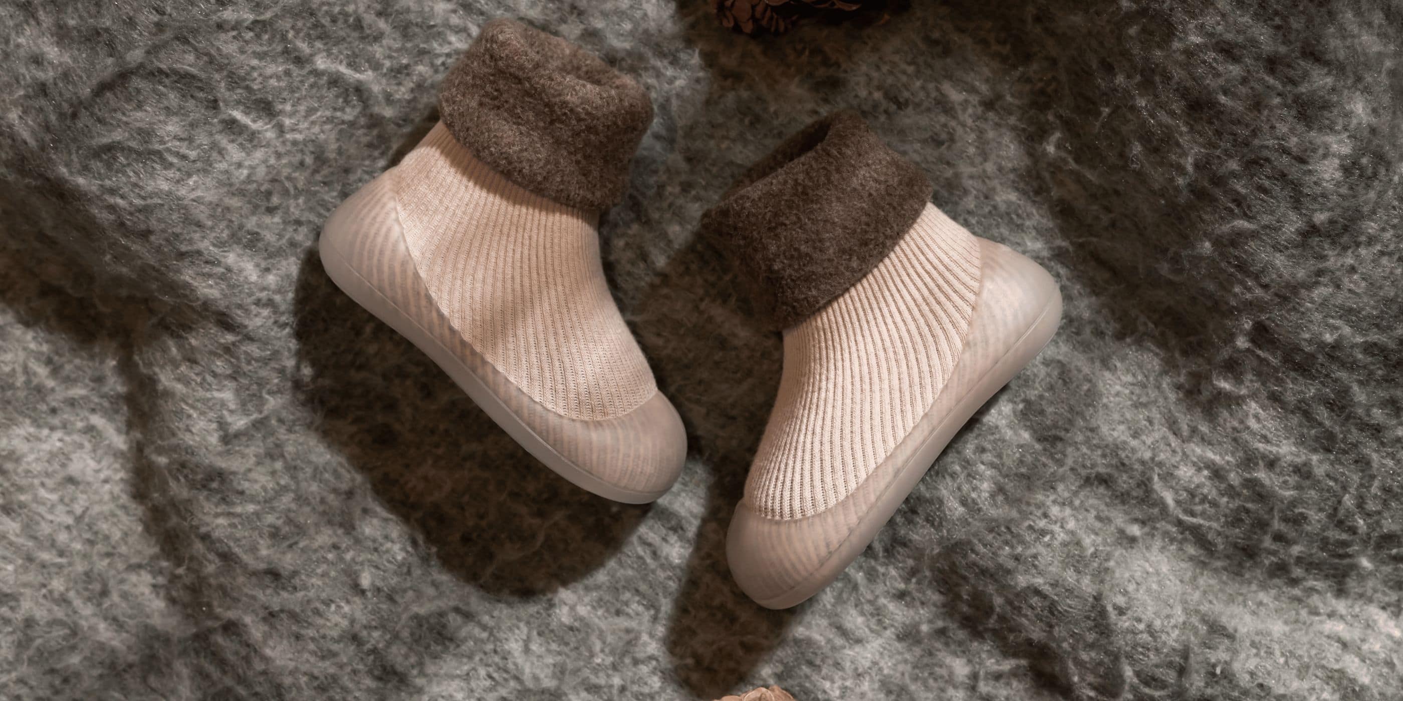 Begyndersko i blødt materiale med skridsikker sål og varm ribkant – ideel til små børn, der tager deres første skridt.