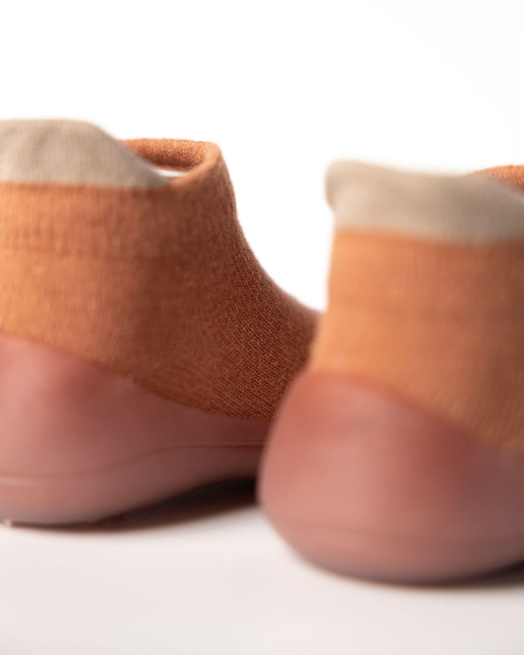 Orange baby begyndersko med blød hælkappe, designet til komfort og stabilitet.