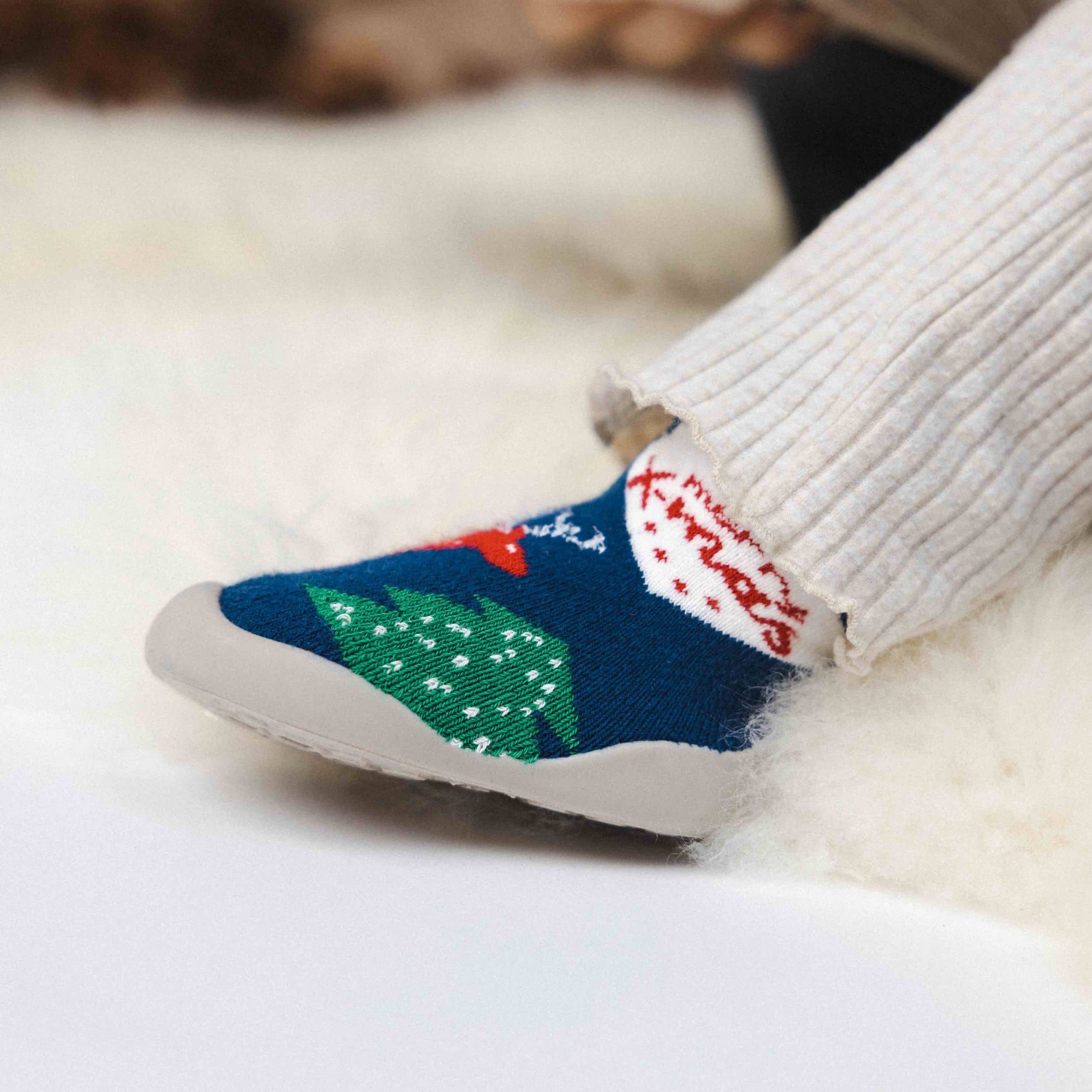 Nærbillede af blå julesko til børn med julemotiv og skridsikker sål.